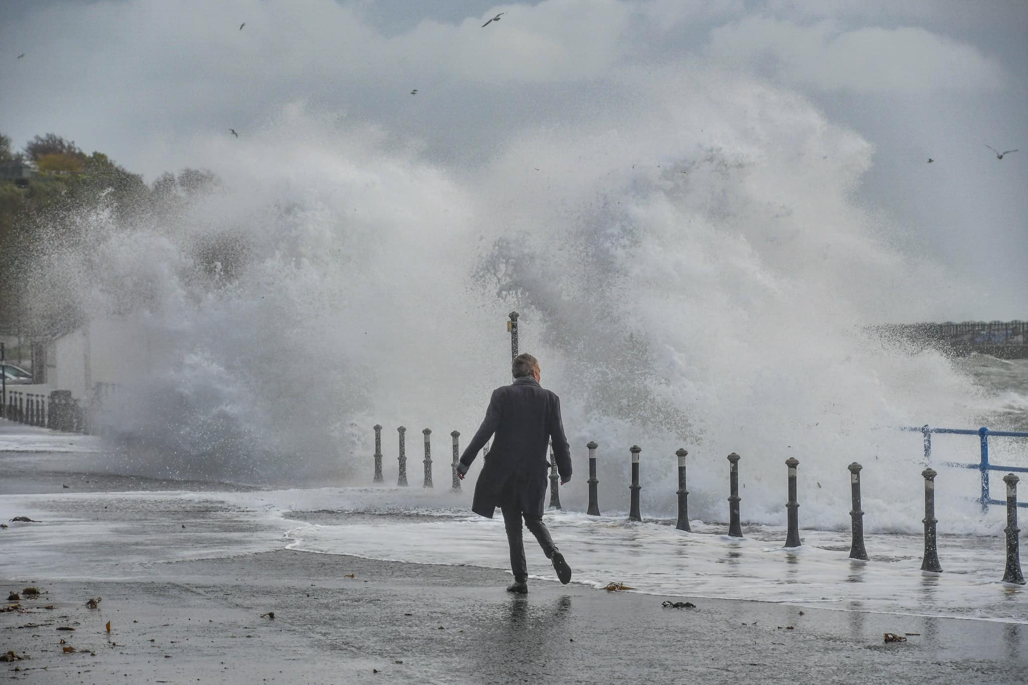 Johnny walking through dramatic coastal storm in Whitehead